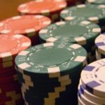 Pilhas de fichas de poker coloridas sobre mesa, sem identificação de operadora
