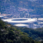 Vista aérea do Estádio do Maracanã, no Rio de Janeiro, cercado por vegetação e área urbana