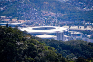 Vista aérea do Estádio do Maracanã, no Rio de Janeiro, cercado por vegetação e área urbana