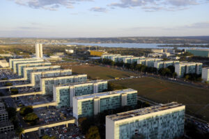 Vista aérea da Esplanada dos Ministérios em Brasília, com prédios dos ministérios e o Congresso Nacional ao fundo
