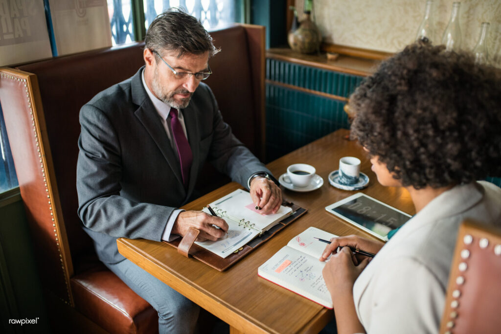Executivos em reuniao de negocios discutindo documentos, imagem ilustrativa de governanca corporativa