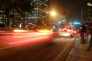 Trânsito noturno na Avenida Faria Lima, principal centro financeiro de São Paulo, com prédios corporativos ao fundo