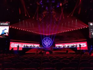 Palco iluminado de arena de eSports durante partida envolvendo a FURIA