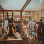 Estatua dourada e preta do deus egipcio Anubis exposta em vitrine de museu