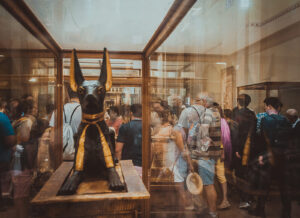 Estatua dourada e preta do deus egipcio Anubis exposta em vitrine de museu