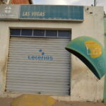 Fachada de casa lotérica com a marca oficial Loterias Caixa, porta fechada