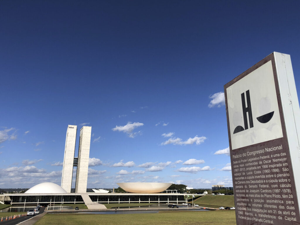 Fachada do Palácio do Congresso Nacional em Brasília, com as duas cúpulas e as torres gêmeas ao fundo.