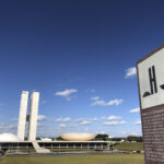 Fachada do Palácio do Congresso Nacional em Brasília, com as duas cúpulas e as torres gêmeas ao fundo.