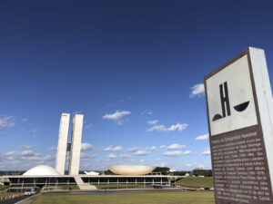 Fachada do Palácio do Congresso Nacional em Brasília, com as duas cúpulas e as torres gêmeas ao fundo.
