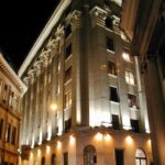 Fachada iluminada do edifício histórico da B3, a Bolsa de Valores de São Paulo, à noite