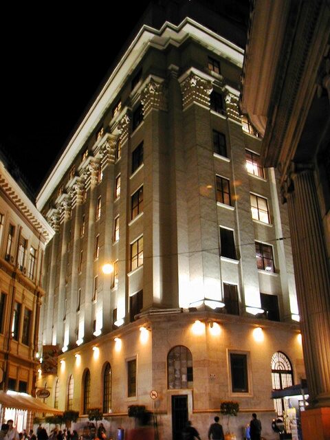 Fachada iluminada do edifício histórico da B3, a Bolsa de Valores de São Paulo, à noite