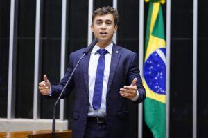 Deputado federal discursando na tribuna do plenário da Câmara dos Deputados, com a bandeira do Brasil ao fundo (Foto de arquivo do plenário da Câmara dos Deputados (2023), sem relação com o plano específico de bloqueio de recursos de bets ilegais, usada apenas para ilustrar o ambiente legislativo onde o tema foi apresentado.)