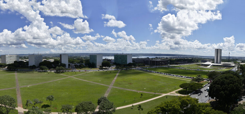 Vista aérea da Esplanada dos Ministérios em Brasília, com prédios do governo e o Congresso Nacional ao fundo