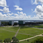 Vista aérea da Esplanada dos Ministérios em Brasília, com prédios do governo e o Congresso Nacional ao fundo