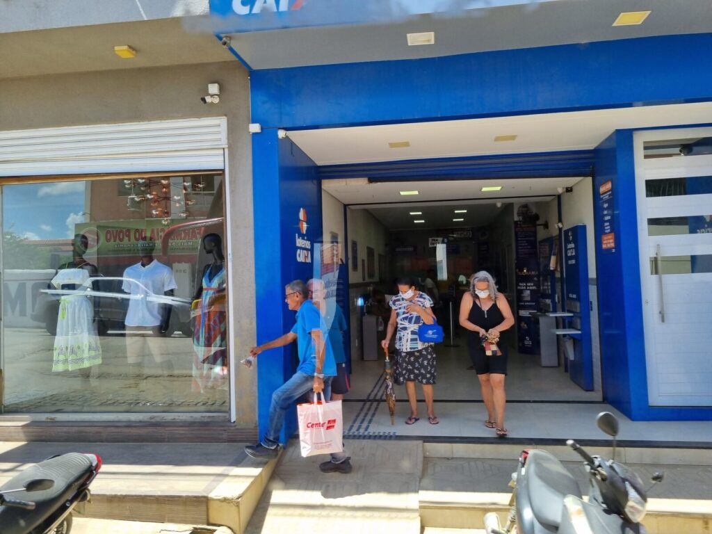 Fachada de agência das Loterias Caixa com clientes na entrada
