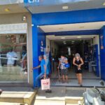 Fachada de agência das Loterias Caixa com clientes na entrada