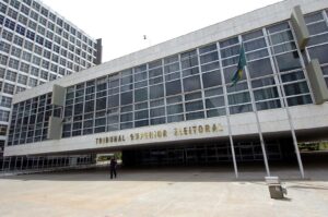Fachada do prédio do Tribunal Superior Eleitoral (TSE) em Brasília, com a placa 'Tribunal Superior Eleitoral' visível e bandeira do Brasil. (Foto de arquivo: sede do Tribunal Superior Eleitoral, em Brasília.)
