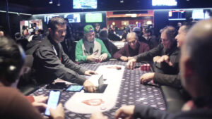 Mesa final de torneio de pôquer com jogadores, fichas e cartas sobre feltro, com telões ao fundo (Foto de arquivo: mesa de torneio de pôquer (World Poker Tour), sem relação direta com o evento BSOP Millions.)